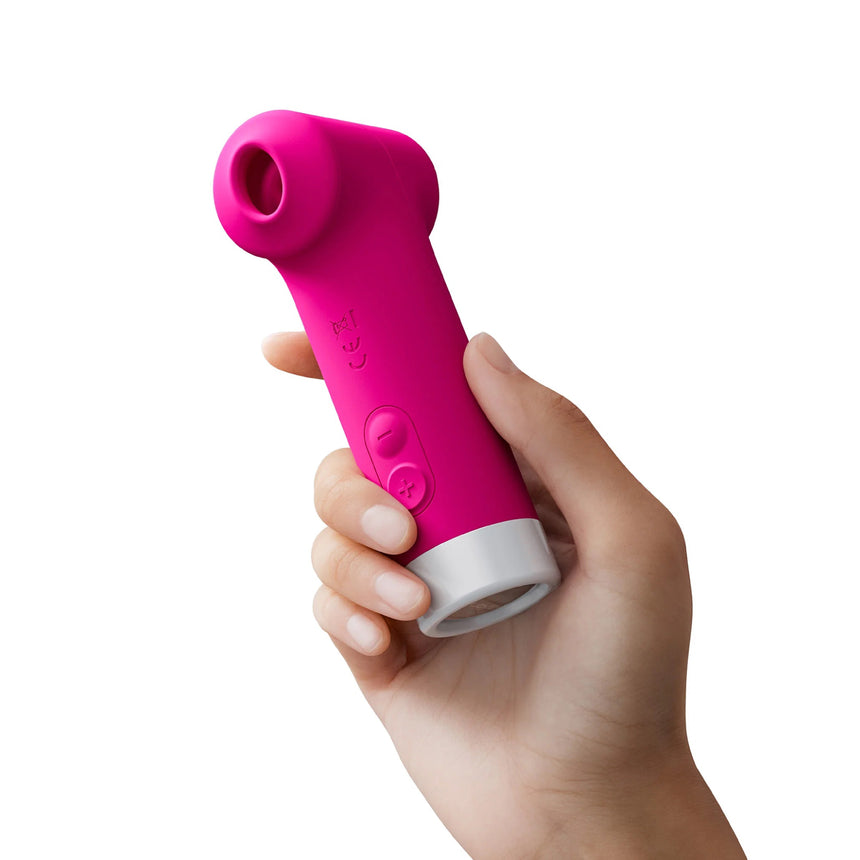 Hand holding the compact pink Lovense Fizz clitoral stimulator to demonstrate palm size and ergonomic grip.