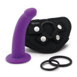 A purple silicone dildo with a curved design, accompanied by a black harness with two white adjustable rings and two black O-rings.
