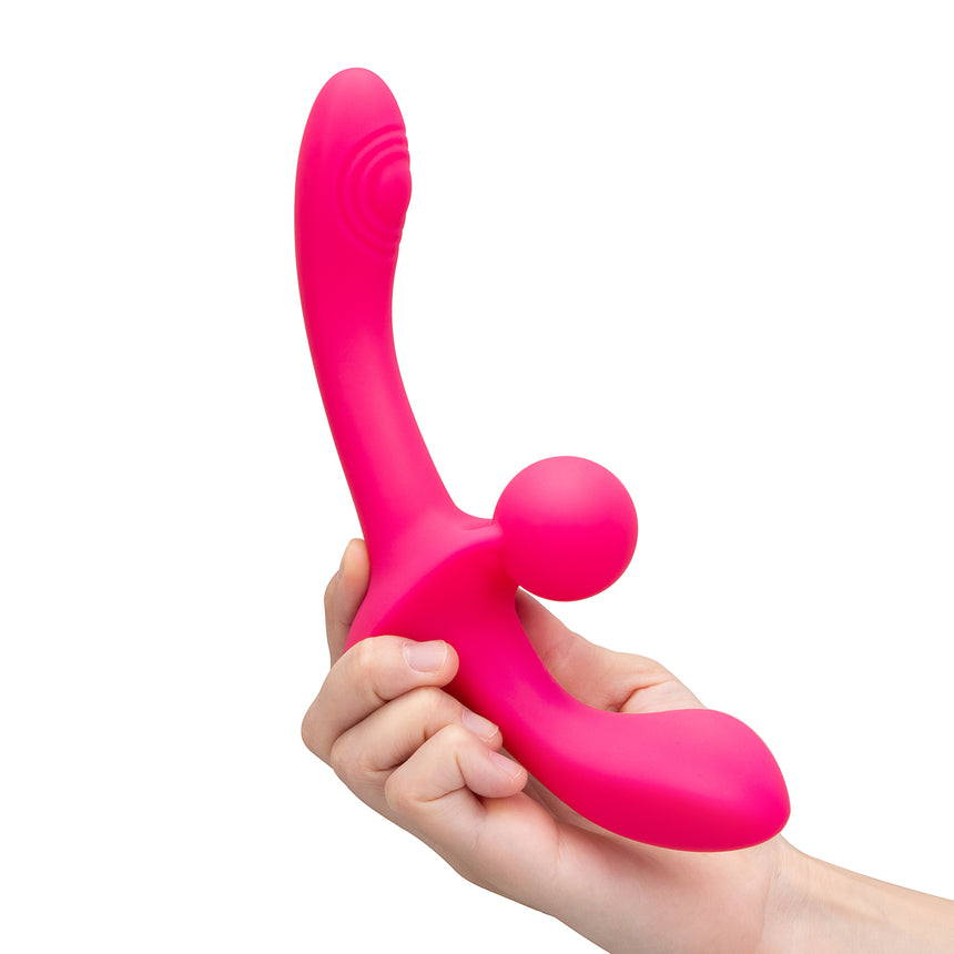 Pink double ended vibrator tool held in a hand against a white background