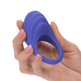 Hand stretching the flexible purple silicone ring on the CalExotics Connect couples stimulator to show fit and elasticity.