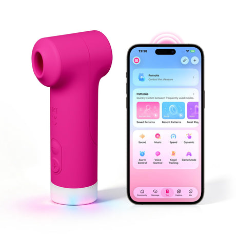 Pink Lovense Fizz dual-head clitoral vibrator standing upright beside a smartphone displaying the Lovense control app.