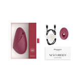 Official retail packaging box for the red Womanizer Next Liberty shown with included USB-C cable and manual.